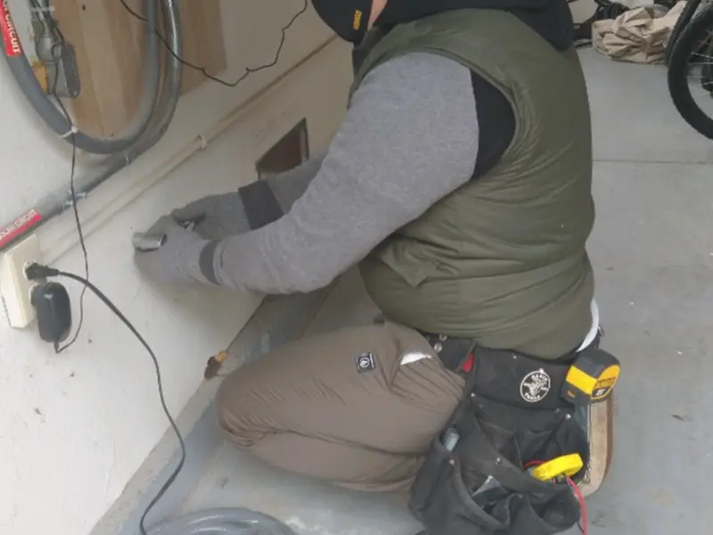 Electrician performing outlet wiring in a Waterloo garage